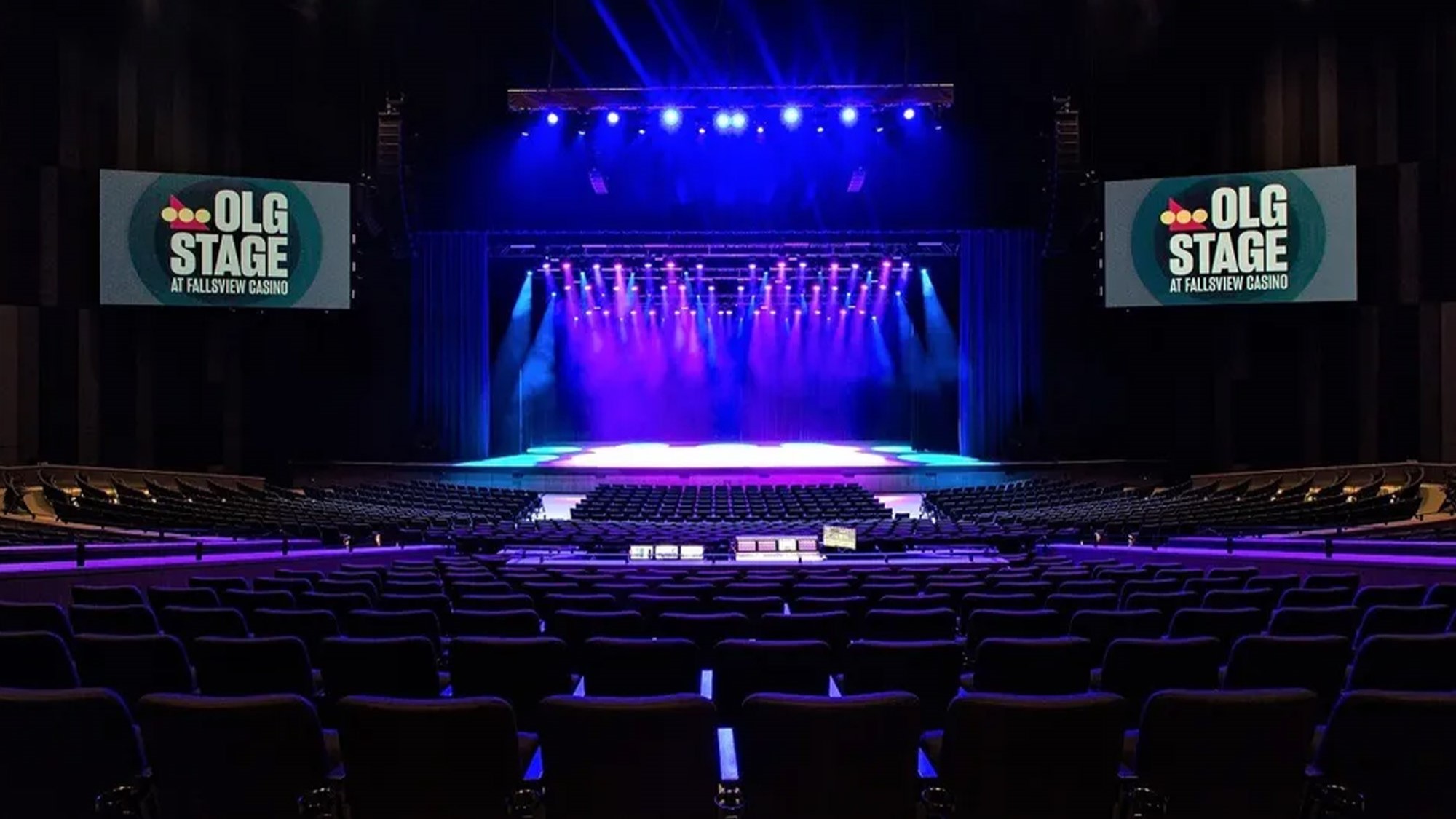 An auditorium venue featuring a large stage and a prominent screen, designed for concerts and performances.