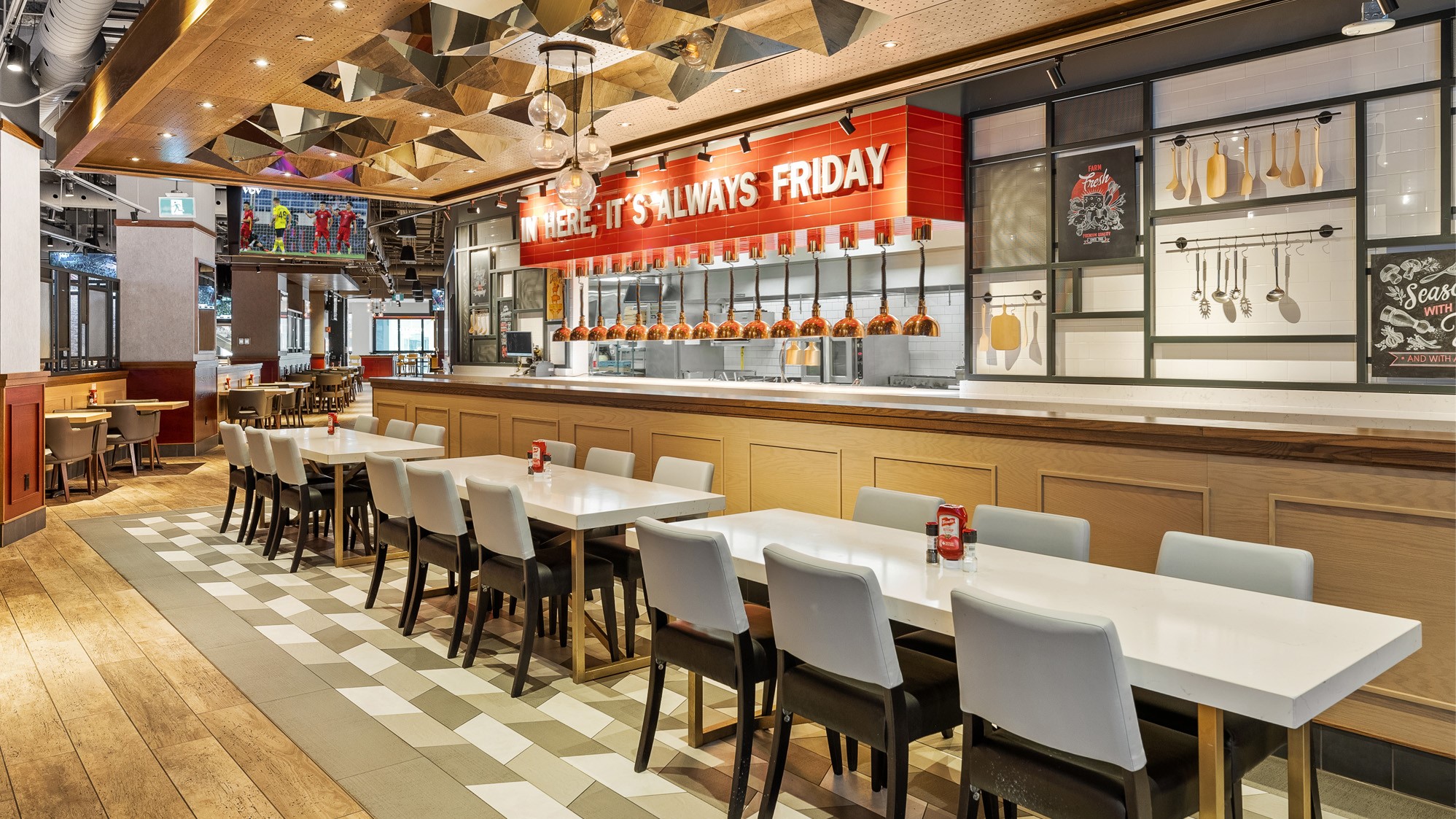 Modern restaurant interior with white tables, gray chairs, and a prominent bar area.