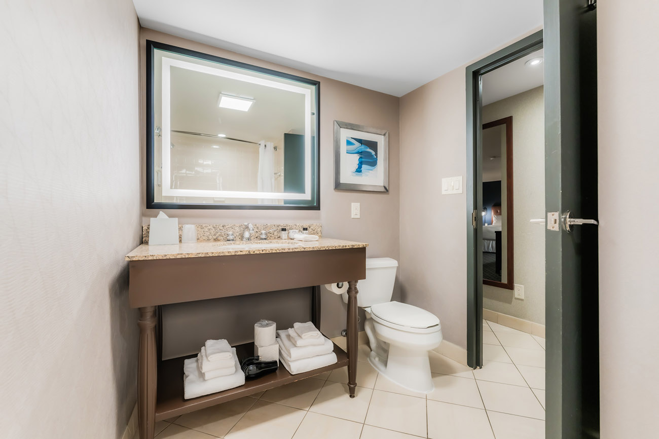 A clean bathroom featuring a sink, toilet, and mirror, showcasing a modern and functional design.