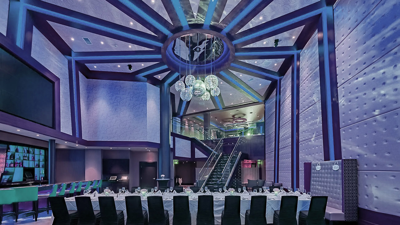 A large room characterized by vibrant walls and a stunning chandelier, contributing to a sophisticated environment.